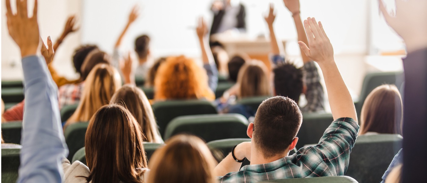 rear-view-of-large-group-of-students-raising-arms-during-a-class-at-picture-id1093523312